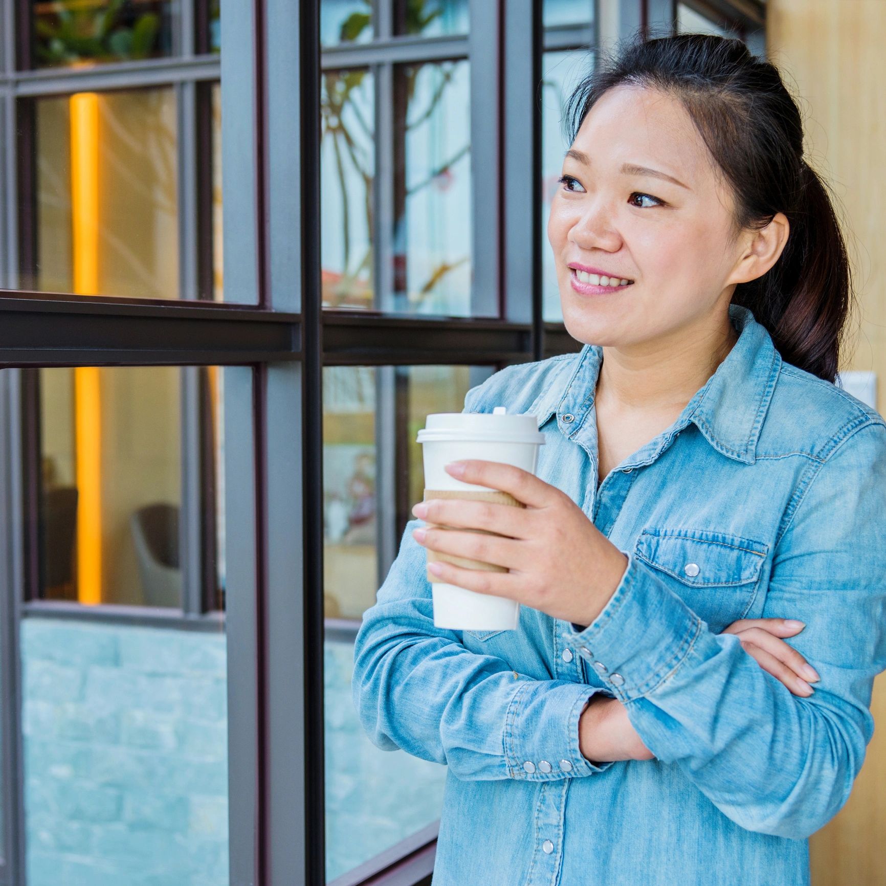 Woman enjoying coffee by a cafe window